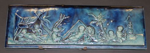 A Burmantofts style rectangular pottery plaque, relief moulded with putti leaning against a lion,