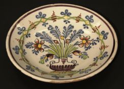 An 18th Century Dutch Delft charger, polychrome decorated with a vase of flowers and foliage,