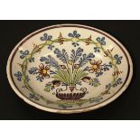 An 18th Century Dutch Delft charger, polychrome decorated with a vase of flowers and foliage,