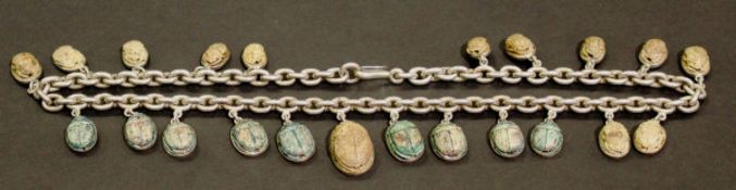 A 19th Century white metal chain with 22 graduated pottery scarabs, each with Egyptian hieroglyphs