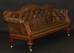 An early Victorian mahogany framed leather button back show frame sofa on turned and ringed front