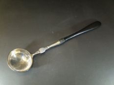 A 19th Century white metal and ebony handled soup ladle,