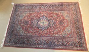 A Persian rug, the central floral medallion in green, pink,