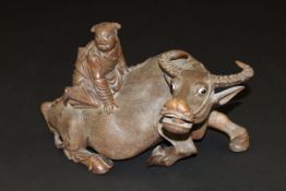 A 19th Century Chinese carved hardwood figure of a water buffalo with inset eyes and teeth,