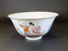 A Chinese porcelain bowl of flared form, painted in the famille-rose palette with ladies and