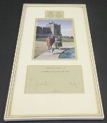 A framed and glazed image of the Royal Family beside a water feature in the grounds of Windsor