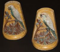 A pair of Compton pottery book ends, relief decorated with parrots upon branch,