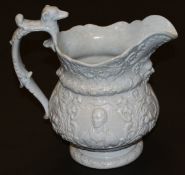 A 19th Century blue glazed relief moulded jug with mask head decoration and the handle with dog's