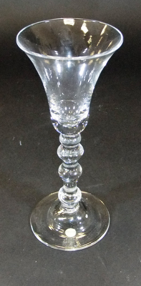 A mid 18th Century wine glass with waisted trumpet shaped bowl, the stem with a top knop, two