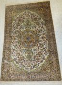 A Persian silk rug, the central medallion with animal and floral decoration in pale green, cream,