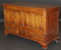 An early 19th Century oak mule chest, the rising lid with moulded edge above a four fielded panel