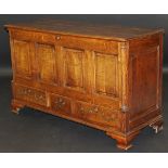 An early 19th Century oak mule chest, the rising lid with moulded edge above a four fielded panel