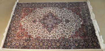 A Persian rug, the central floral decorated medallion in dark blue, grey,