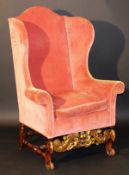 An 18th Century Continental wing back scroll arm chair on carved walnut and gilded base with carved