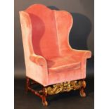 An 18th Century Continental wing back scroll arm chair on carved walnut and gilded base with carved