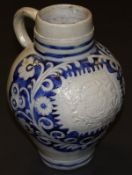 An 18th Century Westerwald salt-glazed stoneware jug with relief moulded decoration depicting an