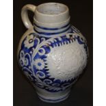 An 18th Century Westerwald salt-glazed stoneware jug with relief moulded decoration depicting an