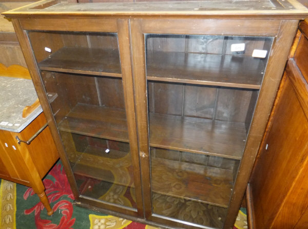 A mahogany display cabinet of two glazed door enclosing shelves