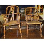 A matched pair of 19th Century West Country ash and elm elbow chairs with spindle back and central