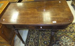 A 19th Century mahogany fold-over tea table on turned and ringed supports