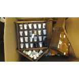 A box containing a large collection of assorted collectors thimbles,