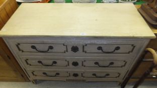 A painted chest of three long drawers with brass handles and escutcheons