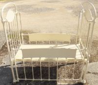 A cream painted metal cot