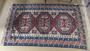 A Turkish rug, the three central linked medallions in cream,