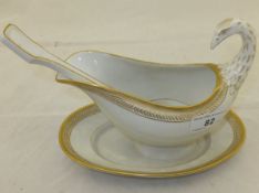 A KPM swan shaped sauceboat and spoon with gilt decoration