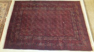 A Bokhara rug with all over repeating medallions on a plum ground within a plum ground border,