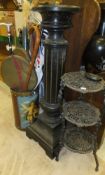 A circular lacquered pedestal on reeded column to square base, a cast iron three tiered stand,