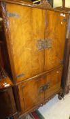 A 20th Century walnut drinks' cabinet in the 18th Century style with two cupboard doors enclosing a