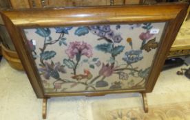 A 19th Century rosewood framed fire screen with long stitch panel depicting flowers and parrot