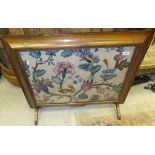 A 19th Century rosewood framed fire screen with long stitch panel depicting flowers and parrot