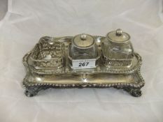 A George III silver inkstand with applied gadrooned edge, raised on four scroll feet (by Edward