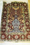 A modern Turkish Hereke silk prayer rug with central scrolling foliate and floral decoration on a