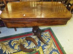 An early 19th Century mahogany fold over tea table on turned and reeded central pedestal to