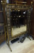 A Victorian brass and flower decorated fire screen with central bevel edged mirror