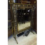 A Victorian brass and flower decorated fire screen with central bevel edged mirror