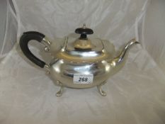 A George VI silver teapot of rounded rectangular form raised on four scroll feet,