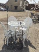 A white painted set of four garden chairs and a circular table,