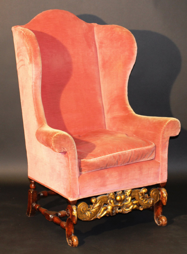 An 18th Century Continental wing back scroll arm chair on carved walnut and gilded base with