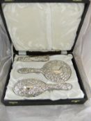 A silver mounted cased dressing table set comprising two hairbrushes and a hand mirror,