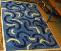 A modern machine woven wool carpet with blue and white scroll decoration on a blue ground,