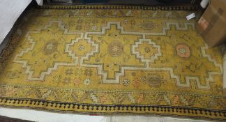 A Caucasian rug (Ngorny Karabakh) with three repeating medallions on a mustard ground,