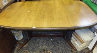 A 1970's Danish teak rounded rectangular extending dining table on end pillar supports united by a