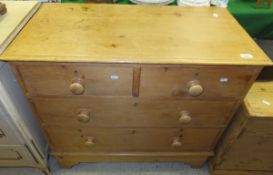 A pine chest of two short and two long drawers with turned wooden handles,