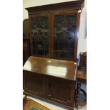 An early 19th Century mahogany bureau with blind fretwork to the cornice enclosing shelves,