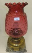 A 19th Century oil lamp with large cranberry and ribbon decorated glass shade (converted to