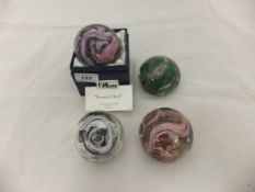 A collection of four art glass studio paperweights of various colours,